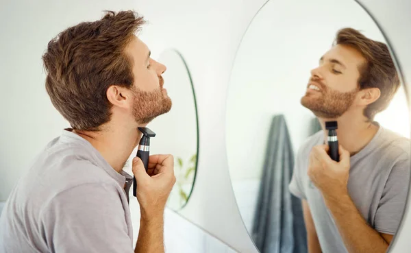 一个英俊的男人在家里的浴室里刮胡子 白人男性用剃须刀照镜子 — 图库照片