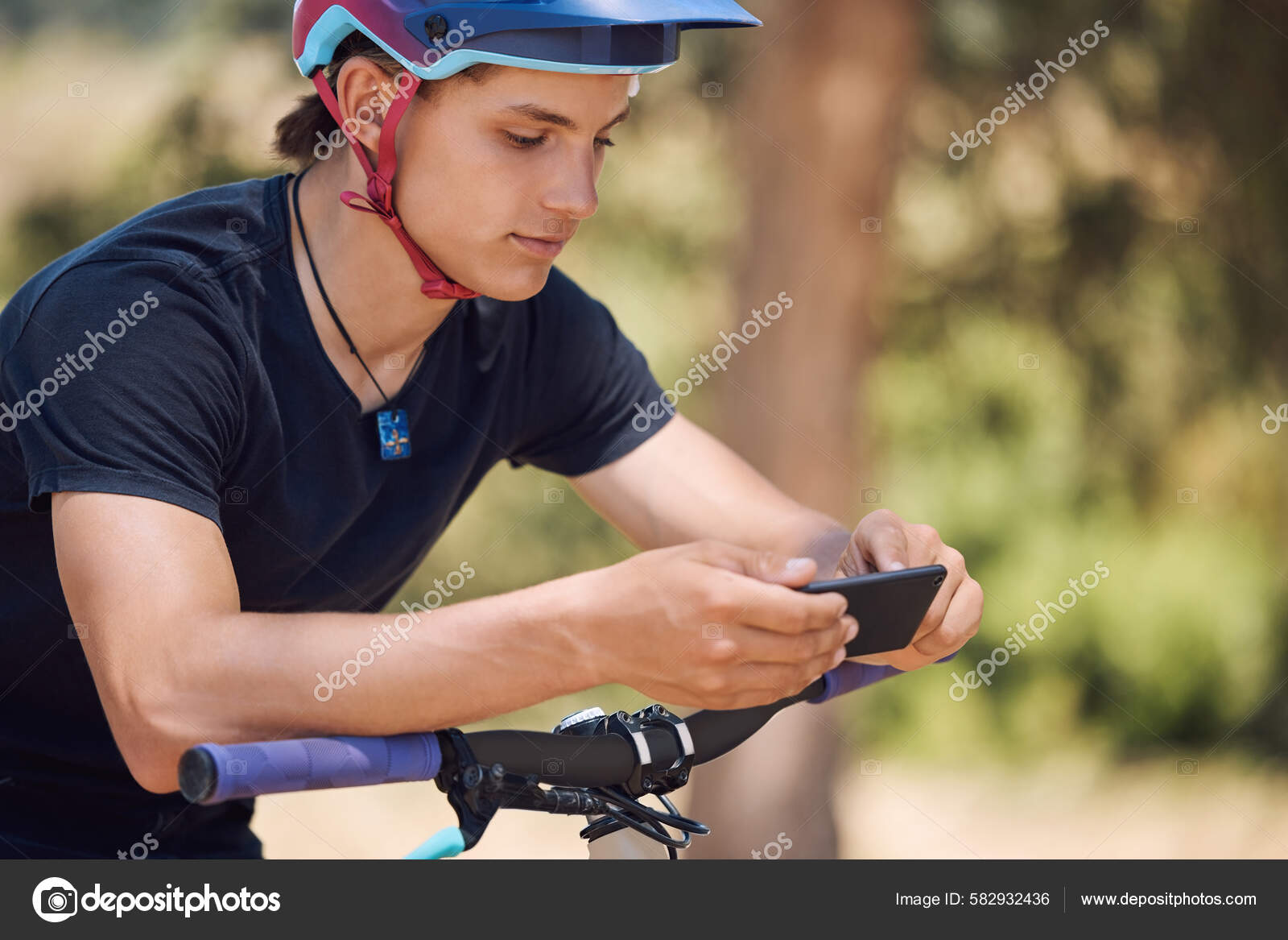 Young Male Cyclist Using Cellphone While Taking Break Cycling