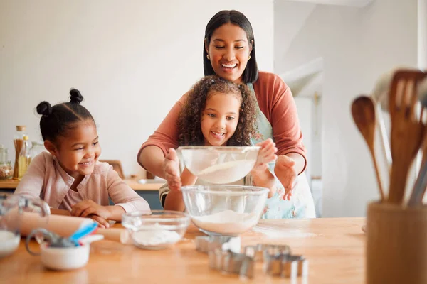 stock image Females only, happy mixed race family of three cooking in a messy kitchen together. Loving black single parent bonding with her daughters while teaching them domestic skills at home.