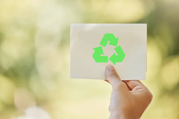 一名身份不明的混血儿拿着一张印有环保和环保回收标志的纸 而外面 用回收符号把他的惊慌失措的女人打扮成绿色 — 图库照片