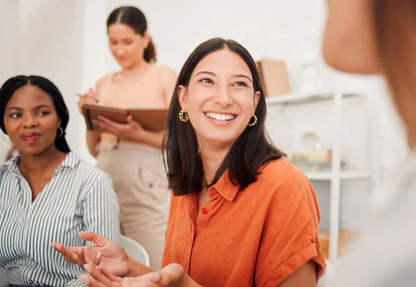 Confident young hispanic business woman speaking to colleagues during a meeting in an office boardroom. Happy staff sharing feedback and explaining ideas while brainstorming in a creative startup