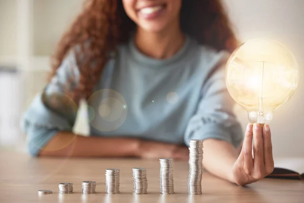 A lineup of coins illustrating a graph and a black woman holding a lightbulb. The growth of a business leads to success and innovation. Any startup requires money and investments to generate ideas