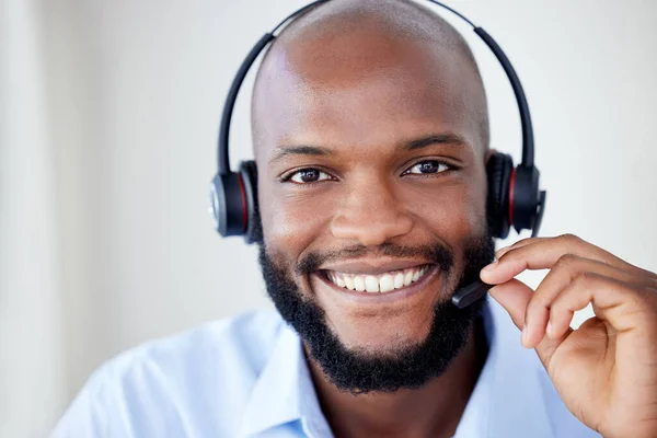 Black sales agents wearing a headset while working in a call centre. Helping with customer care and services.