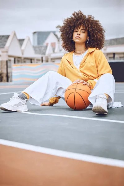 Mixed race woman posing on a basketball court. Beautiful basketball player posing confidently outside.