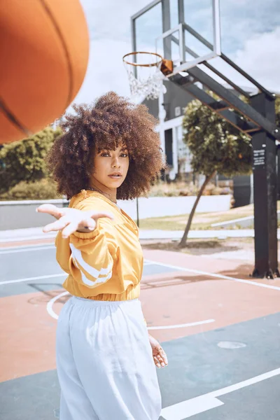 Mixed race woman posing on a basketball court. Beautiful basketball player posing confidently outside.