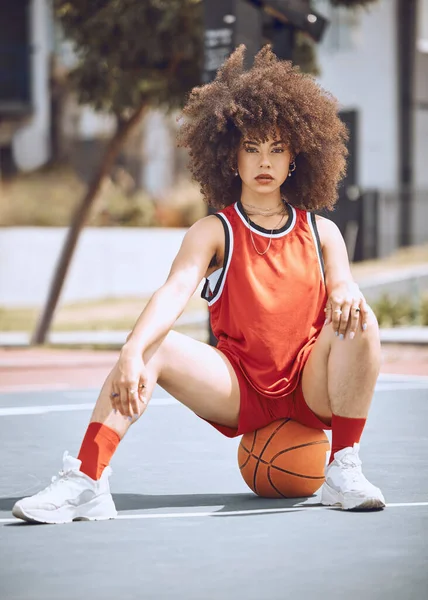 Mixed race woman posing on a basketball court. Beautiful basketball player posing confidently outside.