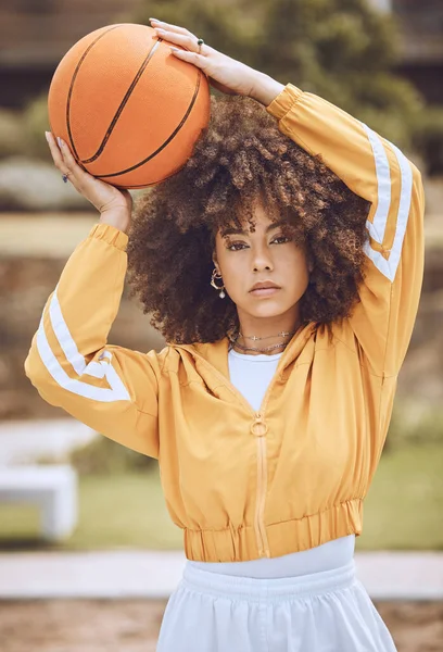 Mixed race woman posing on a basketball court. Beautiful basketball player posing confidently outside.