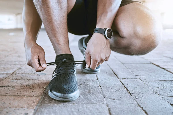 屋外で運動しながら靴ひもを結ぶスポーツマン ランニングやトレーニングの準備をする前にトレーナーを確保する — ストック写真