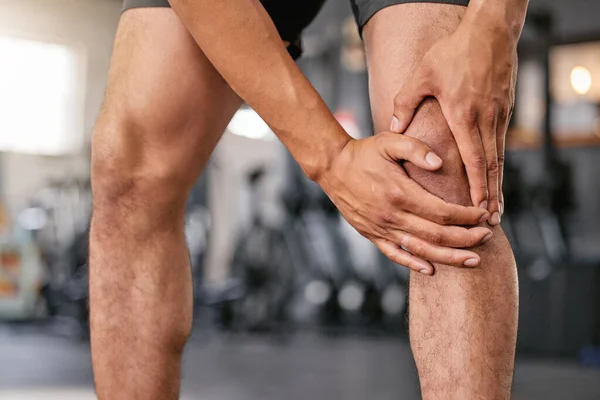 一名高加索男子在健身房锻炼时抱着疼痛的膝盖进行了闭锁 男运动员在运动过程中 因关节骨折和肌肉发炎 腿受伤疼痛 挣扎着与 — 图库照片