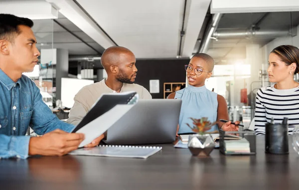 Group of diverse businesspeople having a meeting in an office at work. Business professionals talking in an office. Young african american businesswoman explaining a plan to her coworkers.