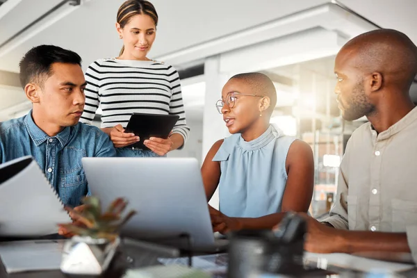 Group of diverse businesspeople having a meeting in an office at work. Business professionals talking in an office. Young african american businesswoman explaining a plan to her colleagues.