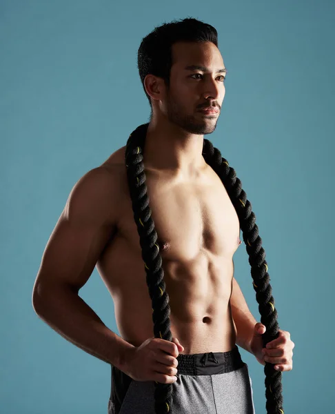Handsome Young Hispanic Man Training Battle Ropes Studio Isolated Blue — Fotografia de Stock