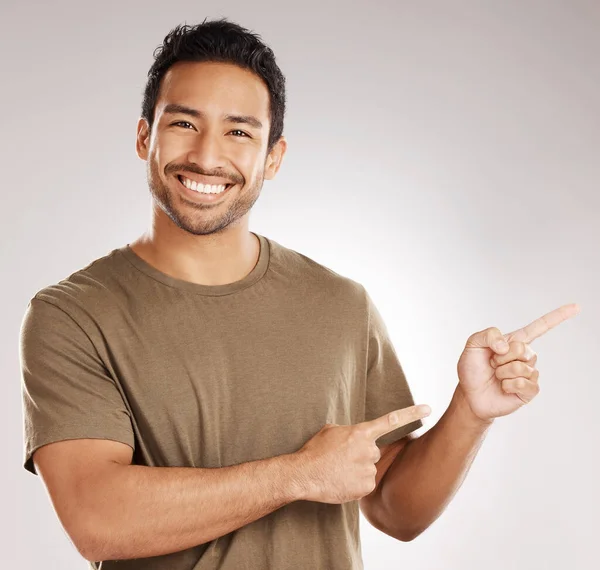 Guapo Joven Mestizo Apuntando Hacia Copyspace Mientras Está Pie Estudio —  Fotos de Stock