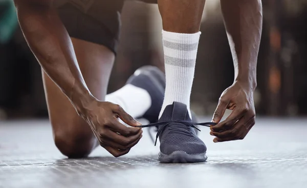 未知のアフリカ系アメリカ人選手の閉鎖は ジムでのトレーニングの前に靴ひもを結び 靴ひもを結びます 健康とスポーツセンターで運動する準備をしている強い フィット感 アクティブな黒人男性 怪我の防止 — ストック写真