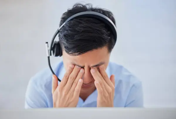 Stressed Young Asian Male Call Centre Agent Getting Headache While — Stockfoto