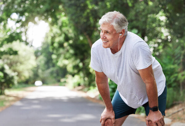 Shot of a mature man catching his breath while exercising outdoors.