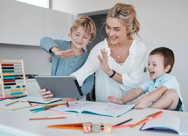 Caucasian mother and her son waving with a hand gesture while using a digital tablet for a video call at home. Two cut boys and woman greeting someone on a call while smiling.