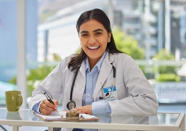 Portrait Happy Indian Doctor Wearing Stethoscope Sitting Office Writing Prescription — Foto Stock