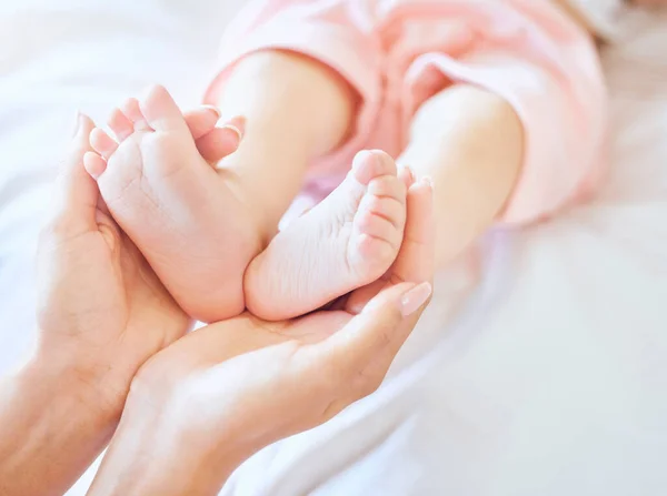 妈妈抱着孩子的脚 由父母抱着的新生儿小脚构成的小团体 小婴儿脚趾头小宝宝躺在床上 女人抱着小女孩的脚 被母亲抱着的无辜婴儿 — 图库照片