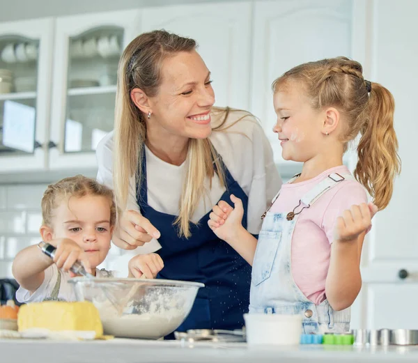 Happy loving family are baking together. Mother and two daughters are cooking cookies and having fun in the kitchen. Homemade food and little helper