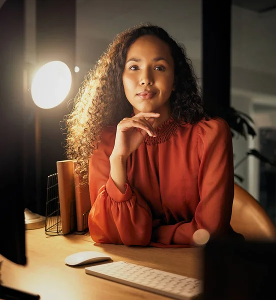 一个自信的年轻女商人晚上在办公室工作时坐在办公桌前的画像 — 图库照片