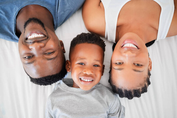 High angle shot of a happy family relaxing on a bed together at home.