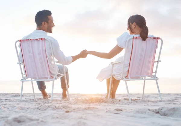 Shot Young Couple Holding Hands While Sitting Beach Chairs — Stockfoto