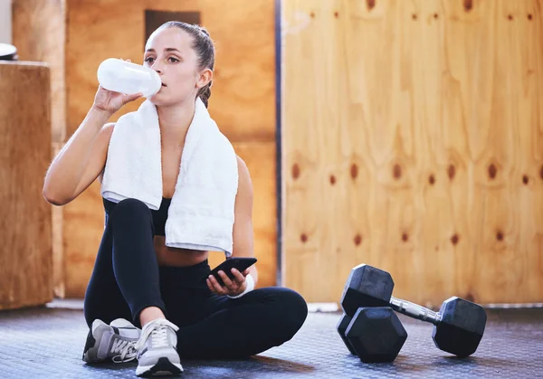 Shot Sporty Young Woman Drinking Water Using Cellphone While Exercising — ストック写真