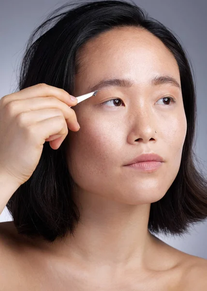 Shot Young Woman Plucking Her Eyebrows Grey Background — Stock Fotó