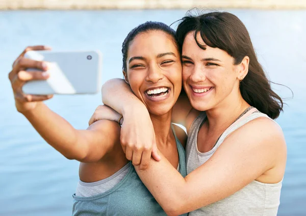 Duas Amigas Tirando Selfies Após Treino Natureza Frente Lago Usando — Fotografia de Stock