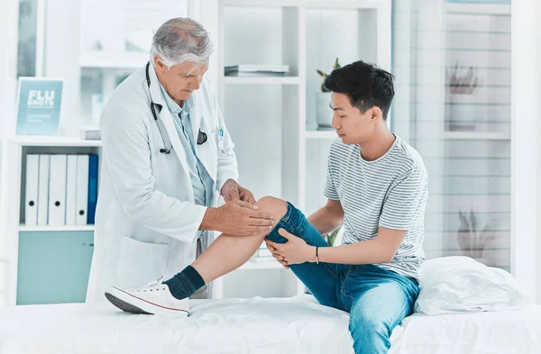 Shot Mature Doctor Checking His Patients Knee Injury — Stock Fotó