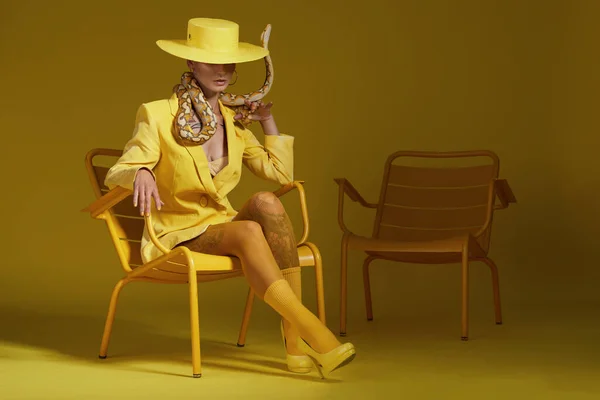 Shot Fashionable Woman Holding Snake While Modelling Yellow Concept — kuvapankkivalokuva