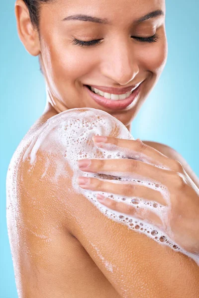 Cropped shot of a woman using a body wash on her skin.