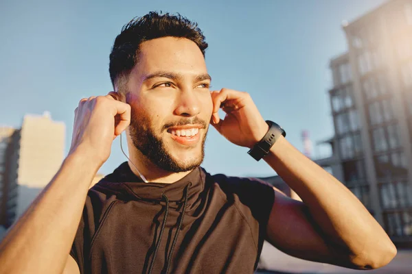 Shot of a sporty young man wearing earphones while exercising outside.