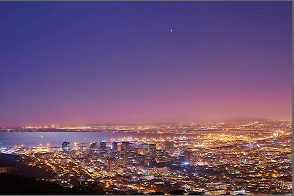 Copy space with twilight night sky over the view of a coastal city seen from Signal Hill in Cape Town South Africa. Scenic panoramic landscape of lights illuminating an urban skyline along the sea.