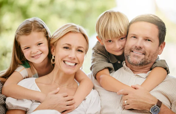 Young cheerful caucasian family enjoying relaxing time together on the weekend at home. Loving little boy and girl hugging their parents while spending time together at home.