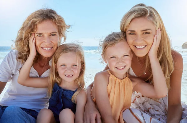 Portrait of a carefree family relaxing and bonding on the beach. Two cheerful little girls having fun with their mother and grandmother on holiday. Mom and grandma love their cute little girls.