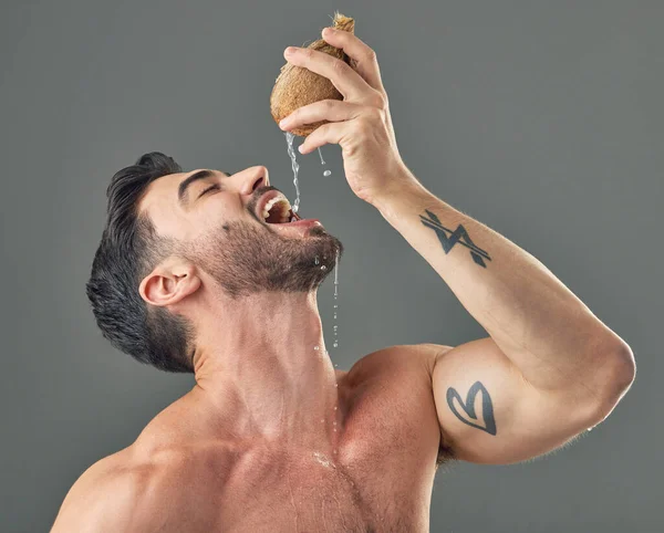 Studio shot of a man drinking coconut water.