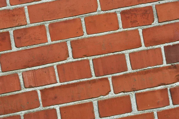 Closeup of a red brick wall with copy space. Detail of recently built exterior masonry or historic design wall background patterns and textures. Outside zoom of modern industrial style architecture.