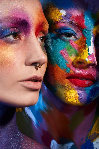 Foto Estudio Dos Mujeres Jóvenes Posando Con Pintura Multicolor Cara —  Fotos de Stock