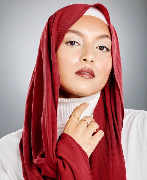 一个穆斯林妇女头戴红色头巾或头巾 显示她的睫毛伸展和化妆的画像 显示她完美的皮肤发光 在灰色工作室背景下被隔离的漂亮女人 — 图库照片