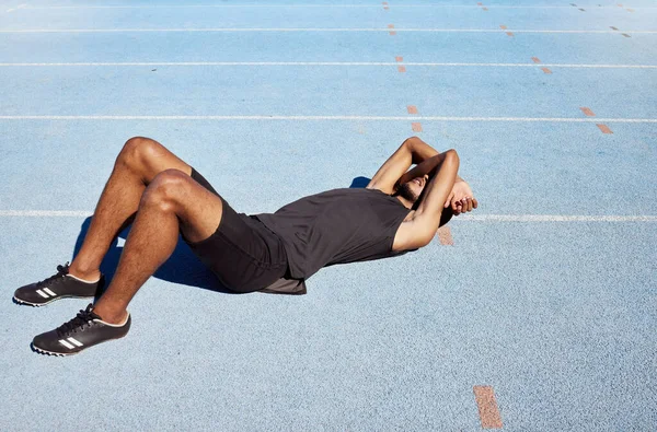疲惫的田径运动员躺下 感到精疲力竭 有竞争力的跑步者 在训练和练习中都会出现精疲力尽 中暑等症状 男人用胳膊捂住脸 — 图库照片