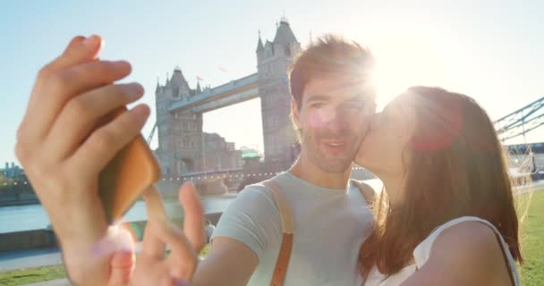 Young Man Taking Selfie While His Girlfriend Kisses His Cheek — Vídeos de Stock