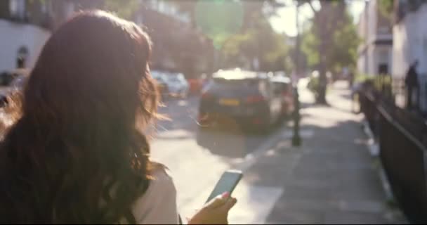 Zadní Video Záběry Mladé Ženy Pomocí Mobilu Při Chůzi Venku — Stock video