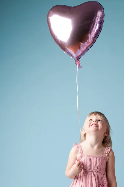 Shot Adorable Little Girl Holding Heart Balloon Studio Background — Stok Foto