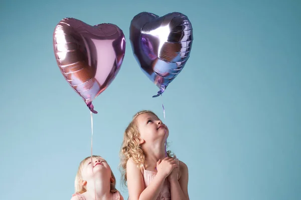 Shot Two Cute Sisters Playing Heart Balloons Studio Background — Stok Foto