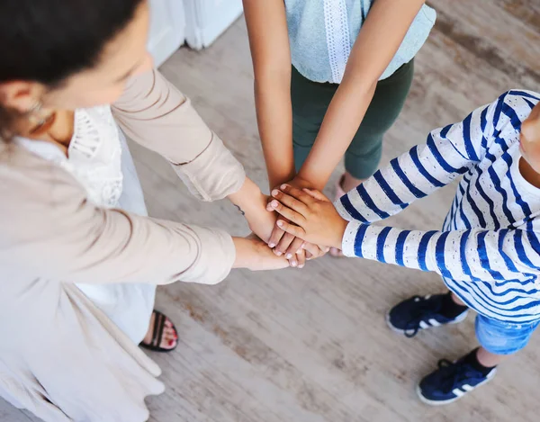 Shot of an unrecognizable family with stacked hands at home.