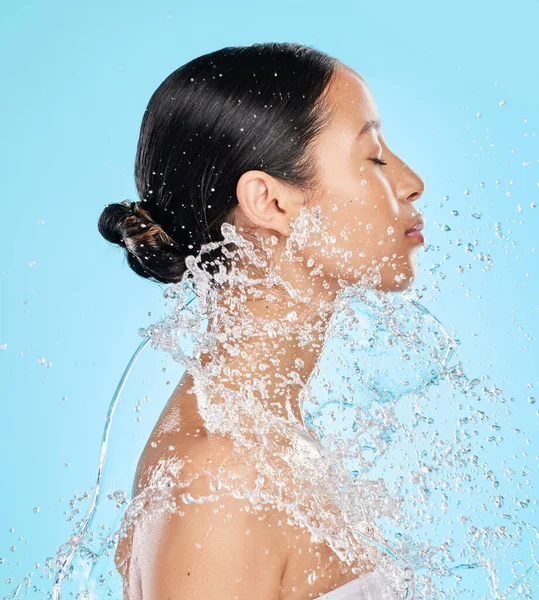 青い背景に水を浴びせられている美しい若い女性のショット — ストック写真