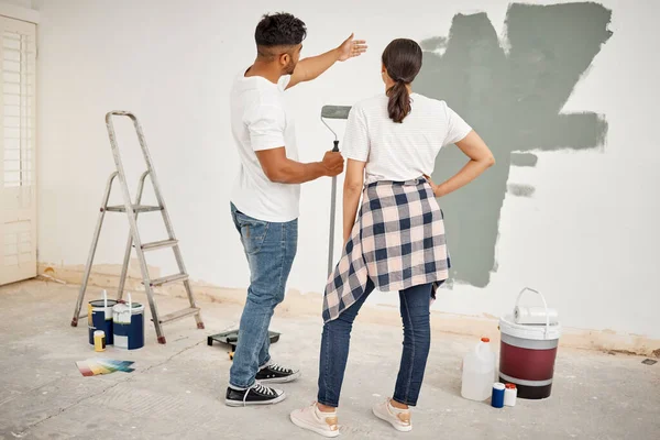 Shot of a young couple painting a room together.