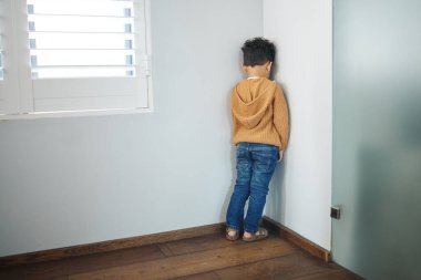 Tanımlanamayan küçük bir çocuğun duvara bakması ve evdeki bir odada ceza olarak çekilmesi..